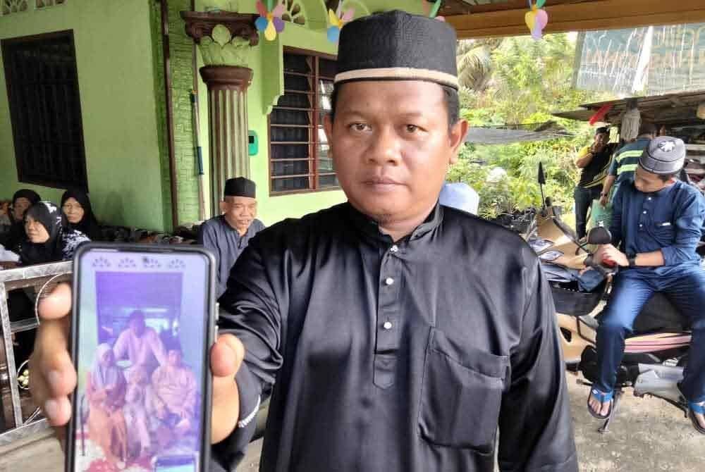 Mohd Nazim menunjukkan gambar adik serta kedua ibu bapa yang ada dalam simpanannya.