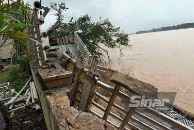 Laluan pejalan kaki di tebing Sungai Kelantan yang runtuh dan pokok tumbang pada Isnin.