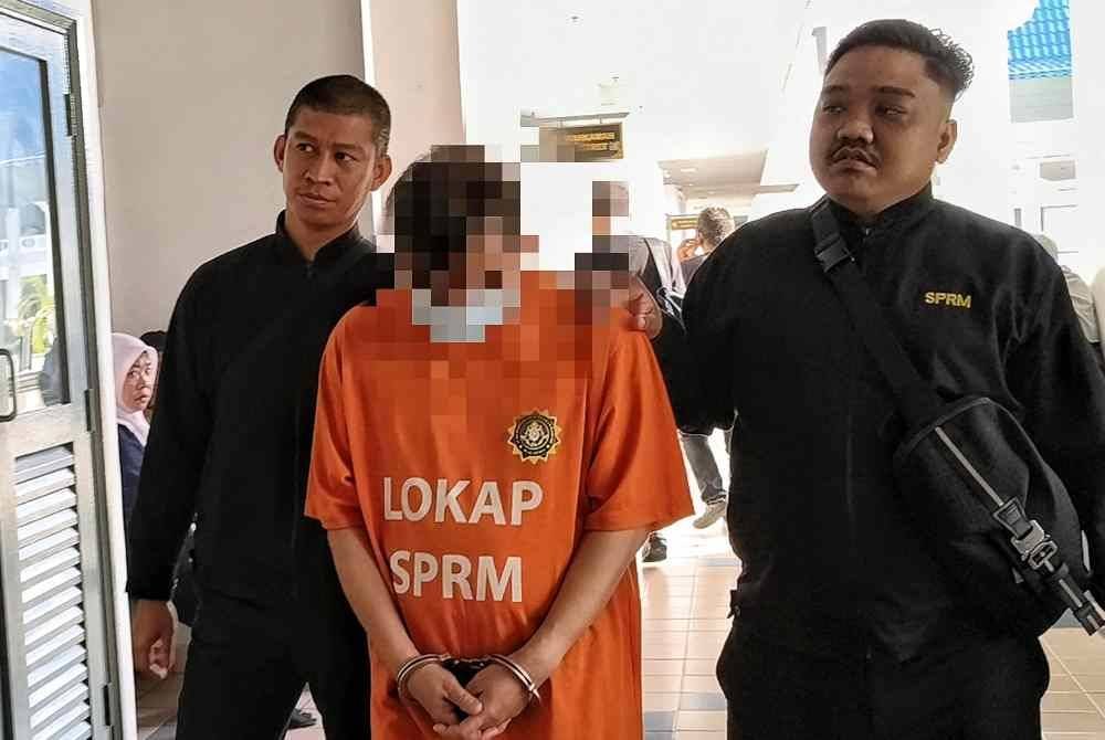 Suspek (tengah) ketika dibawa ke Mahkamah Majistret untuk permohonan reman.