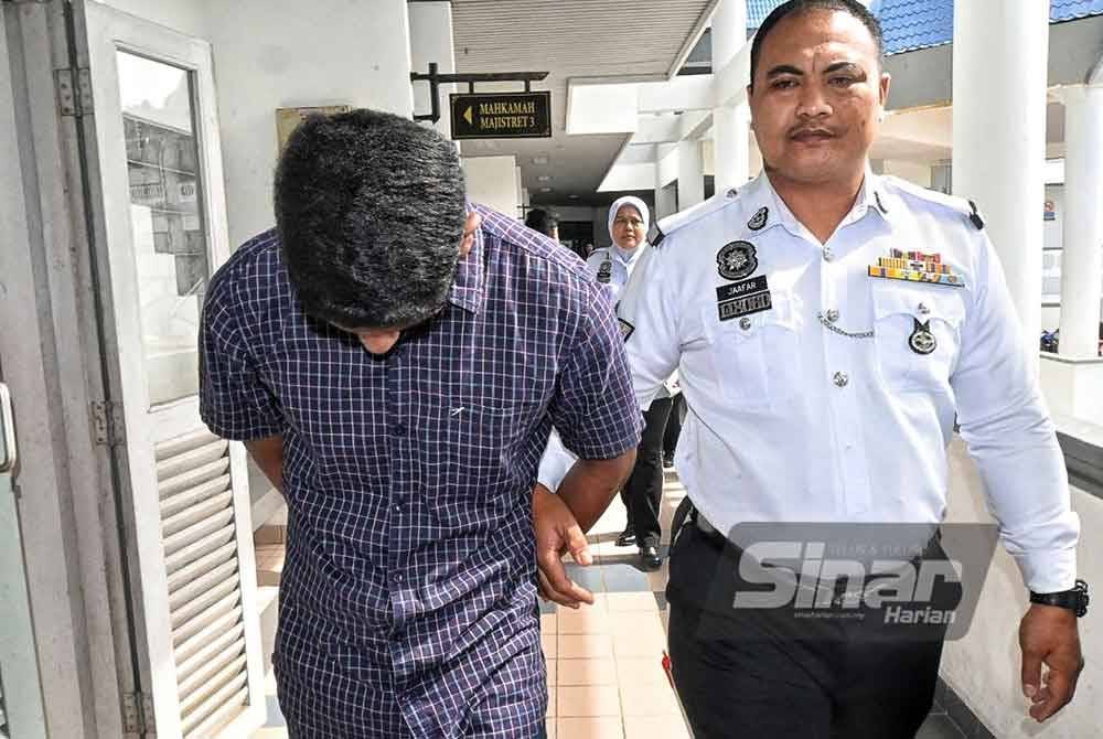 Vinudharan (kiri) ketika dibawa keluar dari Mahkamah Majistret Melaka pada Selasa.