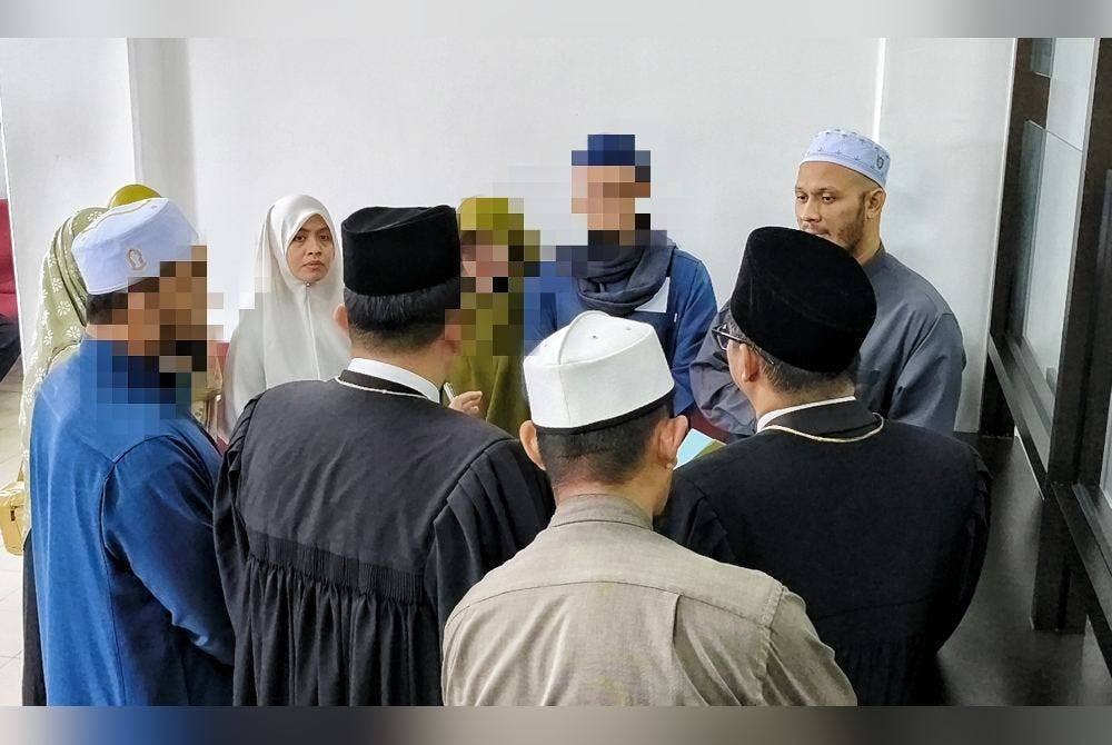 Ummu Habibah (dua,kiri) dan suaminya Muhammad 'Athoullah (kanan) ketika bertemu dengan peguam mereka.