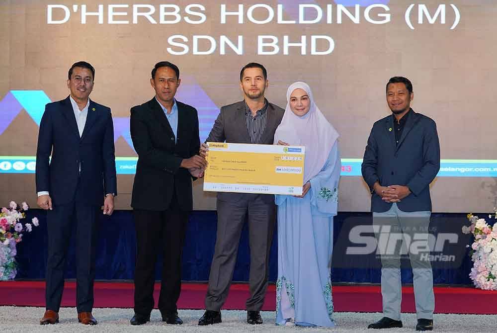 Mohd Sabirin (dua dari kiri) menerima bayaran zakat perniagaan daripada D’Herbs Holding (M) Sdn Bhd pada Majlis Iktiraf Muzakki dan Penyerahan Zakat (IMTIYAZ) 2024 di Menara PKPS pada Khamis. Foto SINAR HARIAN-MOHD HALIM ABDUL WAHID