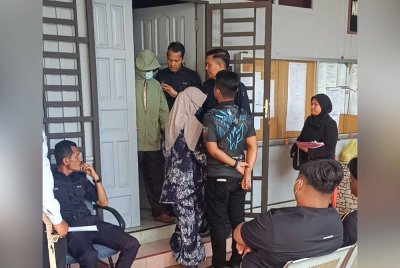 Suspek keluar dari mahkamah selepas selesai prosiding.