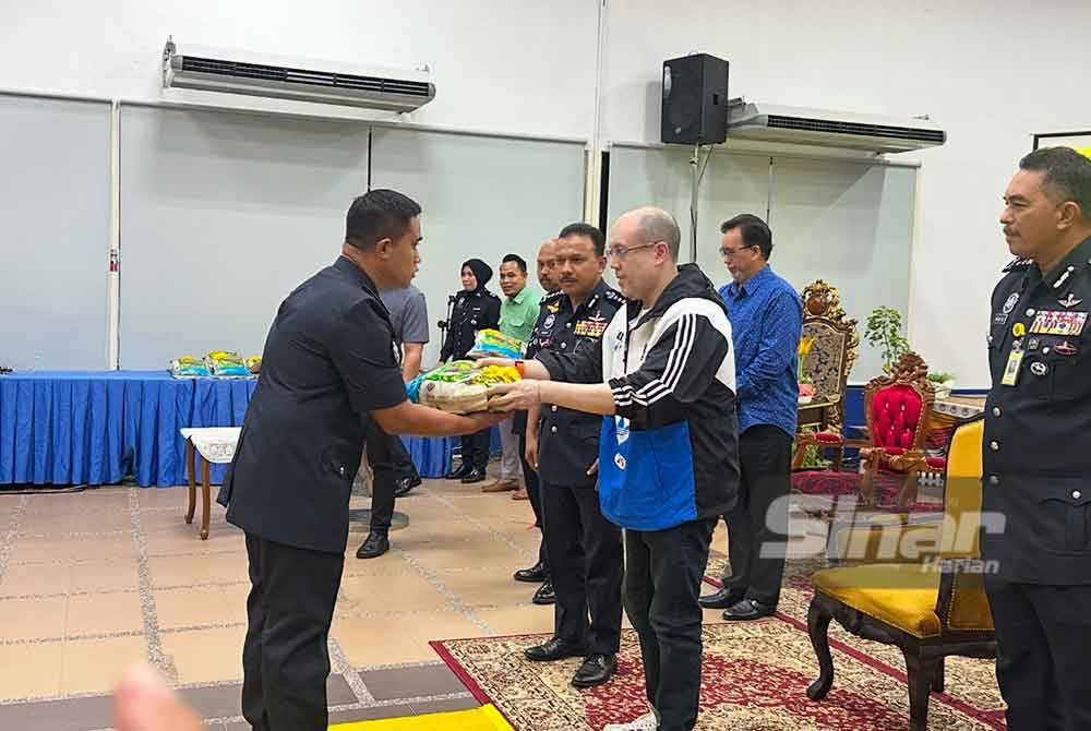 Anggota terjejas banjir menerima sumbangan beras disampaikan oleh Tengku Muhammad Fakhry (tiga dari kanan).Foto Sinar Harian/ADILA SHARINNI WAHID.