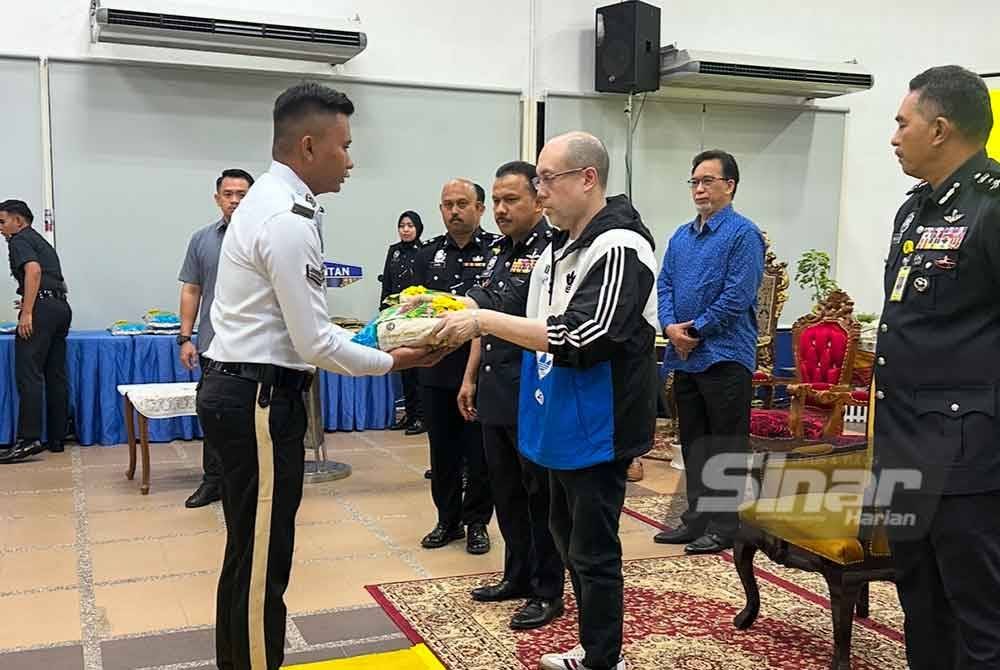Tengku Muhammad Fakhry (tiga dari kanan) berkenan menyampaikan sumbangan kepada anggota polis trafik terjejas banjir. Foto Sinar Harian/ADILA SHARINNI WAHID.