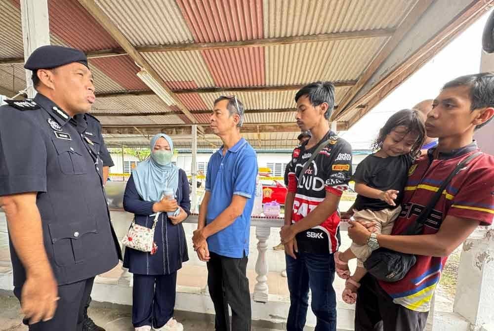 Sazalee (kiri) menerangkan mengenai operasi SAR kepada keluarga Muhamad Ikmal di Jeti Nelayan Kuala Sungai Pinang pada Sabtu.