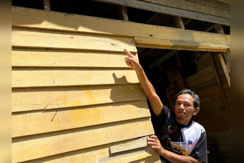 Fauzi menunjukkan paras air semasa banjir baru-baru ini.