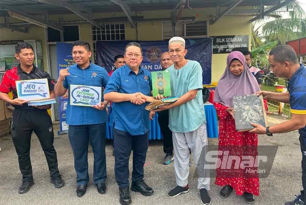 Nik Yusaimi (tiga dari kanan) menyampaikan al-Quran baharu kepada mangsa banjir, Zakaria Omar (tiga dari kanan). Foto SINAR HARIAN-ADILA SHARINNI WAHID