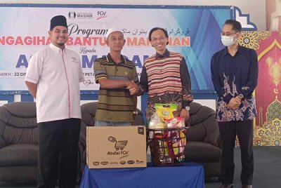 Ahmad Azrin (dua dari kanan) bergambar bersama penerima bantuan serta.Ilyas Helmi (kiri) pada Program Bantuan Makanan MAIDAM pada Ahad