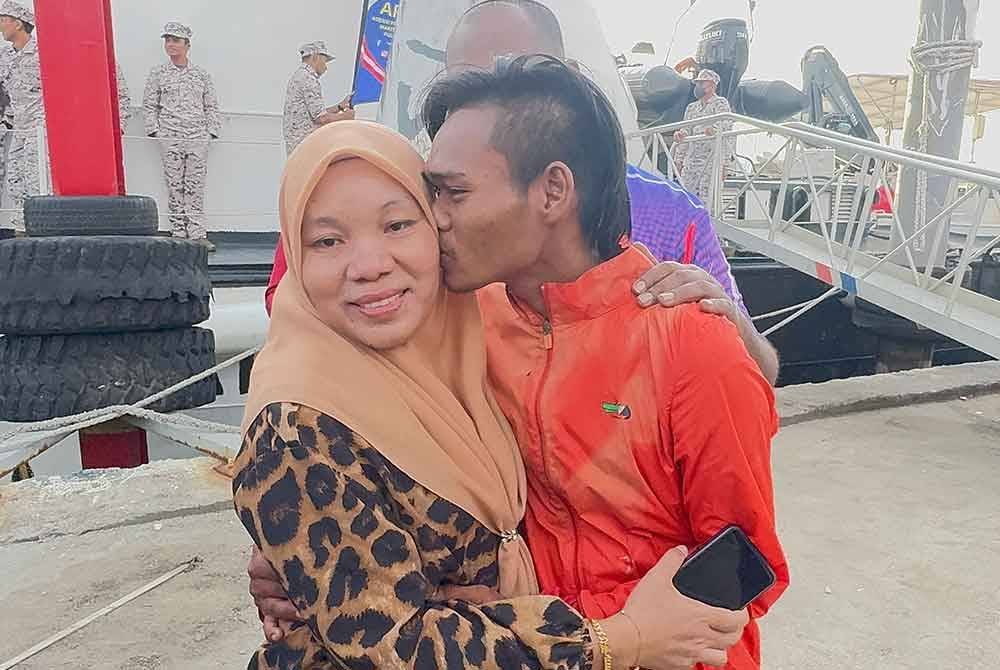 Nor Hasrul mencium ibunya, Noor Azilah Jamaluddin ketika ditemui di Jeti Limbongan Batu Maung pada Isnin.