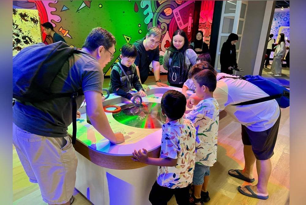 Pengunjung mencuba pameran interaktif di Petrosains 'The Discovery Centre'.