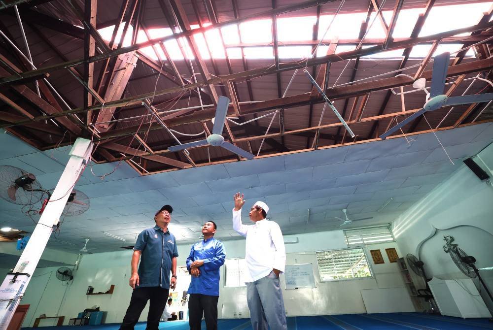 Imam Rawatib Masjid As Salam Sakat (kanan) menceritakan detik-detik kejadian ribut yang menyebabkan kerosakan pada masjid kepada Alexander (kiri) yang melawat Kampung Selamat pada Isnin. Foto Bernama
