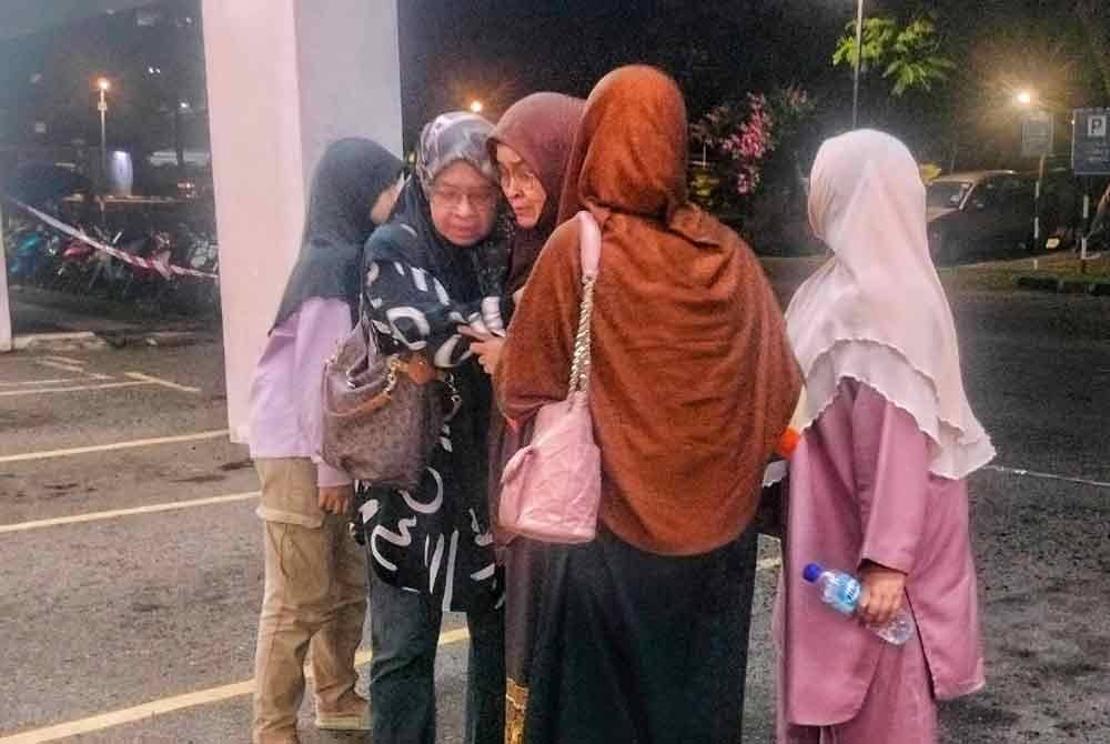 Ibu Allahyarham Khairul Ikhwan Mazupi dipeluk ahli keluarga sebaik tiba di pekarangan di Jabatan Perubatan Forensik Hospital Melaka pada pagi Selasa.