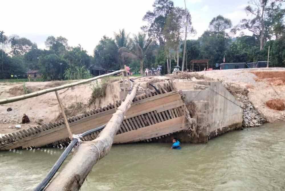Jambatan yang runtuh akibat arus sungai deras ketika banjir tiga minggu lalu dan diganti titi batang durian.