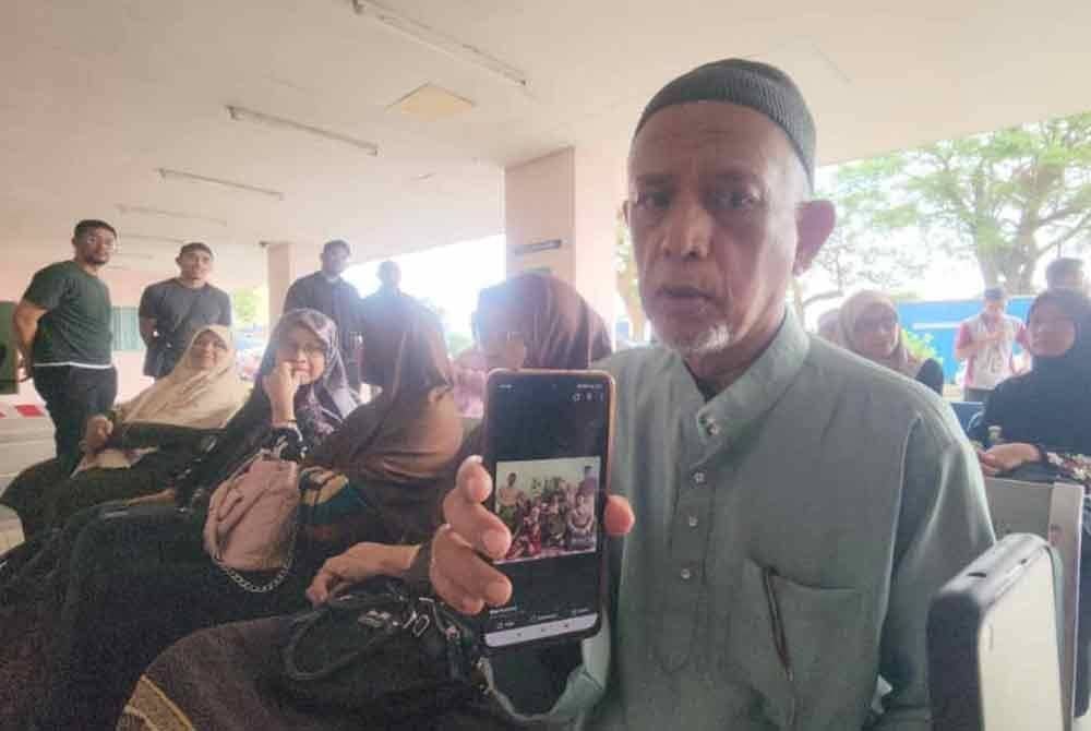 Bapa Allahyarham Khairul Izwan Mazupi, 32, Datuk Mazupi Abdul Rahman yang juga pesara polis menunjukkan gambar kenangan arwah sekeluarga ketika ditemui di Jabatan Forensik Hospital Melaka pada Selasa.