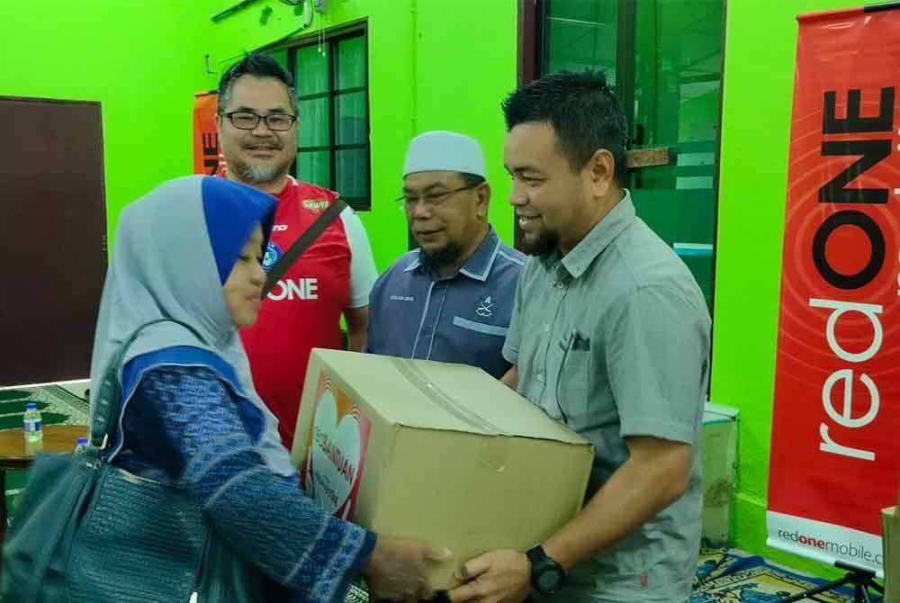 Steven dan Rosli menyaksikan penyerahan Sumbangan Prihatin redONE Pahang kepada penerima disempurnakan Wan di Masjid Kampung Kempadang pada Selasa.