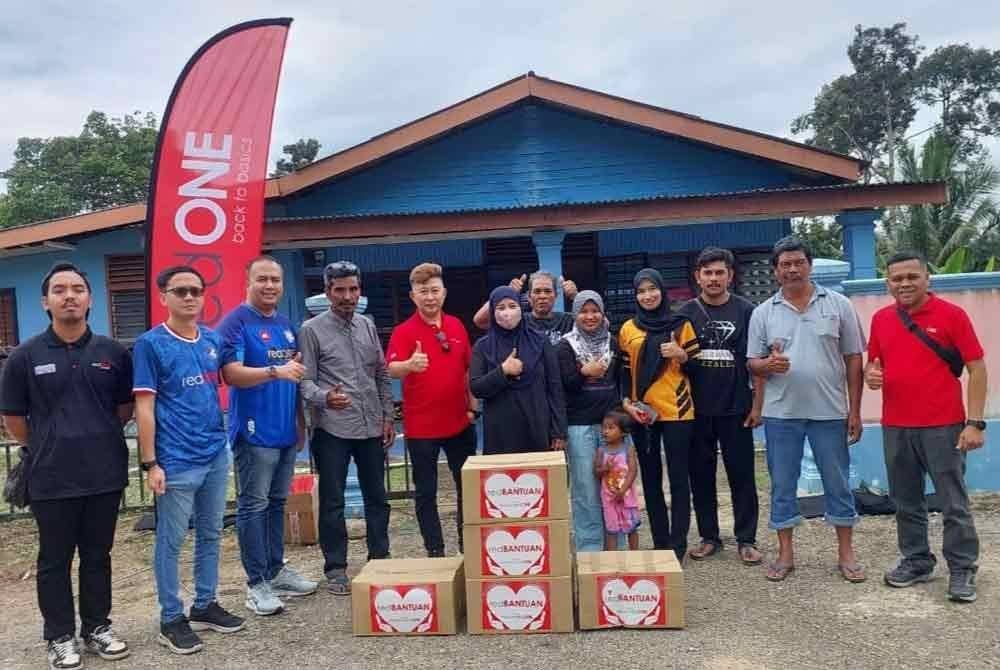 Mohd Nazmun (kanan) bersama kakitangan reONE dan sebahagian penerima Sumbangan Prihatin redONE Pahang pada program agihan di Balai Raya Kampung Jara, Maran pada Isnin.