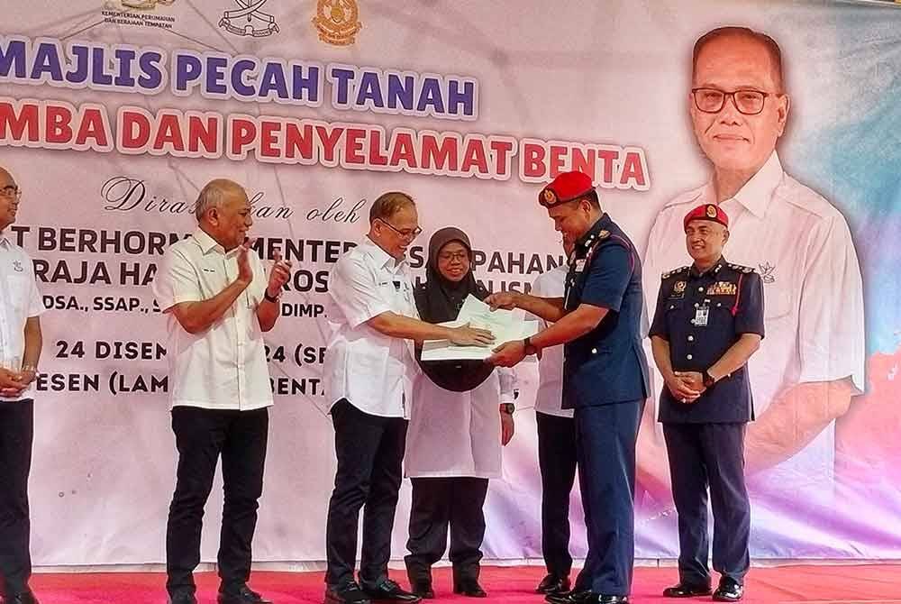 Wan Rosdy(tiga dari kiri) menyerahkan suratan hak milik tanah balai itu kepada Ketua Pengarah Jabatan Bomba dan Penyelamat Malaysia (JBPM) Datuk Ts. Nor Hisham Mohammad