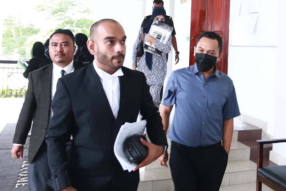 Fikri (kanan) ditemani peguam dihadapkan ke Mahkamah Sesyen di sini pada Selasa.