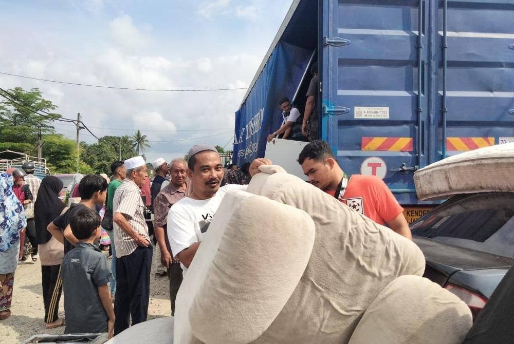 Mohd Harman melihat kerusi yang diterima ketika agihan perabot terpakai.