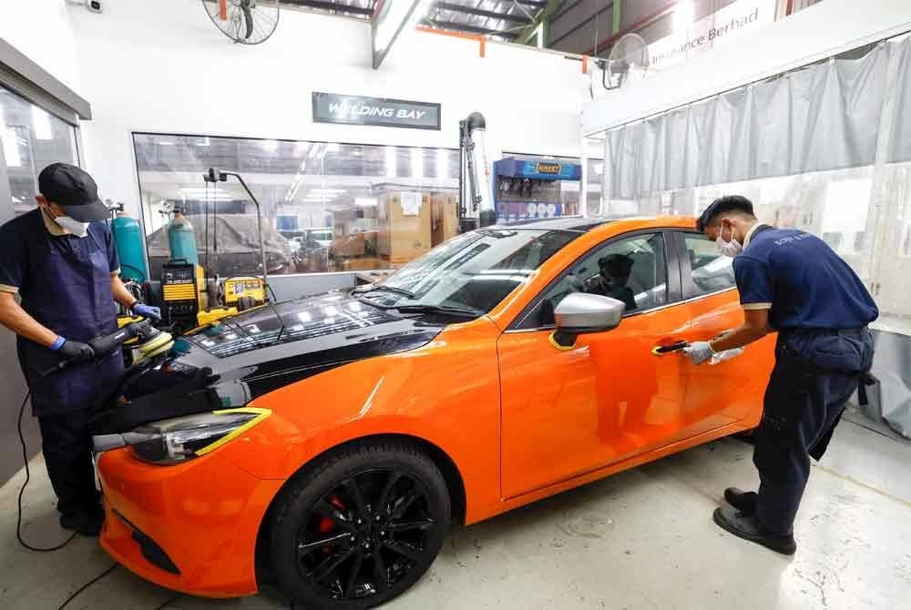 Pelatih Sekolah Latihan Bermaz Auto Berhad bagi perantis Program Sistem Latihan Dual Nasional (SLDN) Pendidikan dan Latihan Teknikal dan Vokasional (TVET) melakukan kerja-kerja pembaikan pada bahagian luaran kereta di Pusat Latihan Mazda (Body and Paint), baru-baru ini. Foto Bernama
