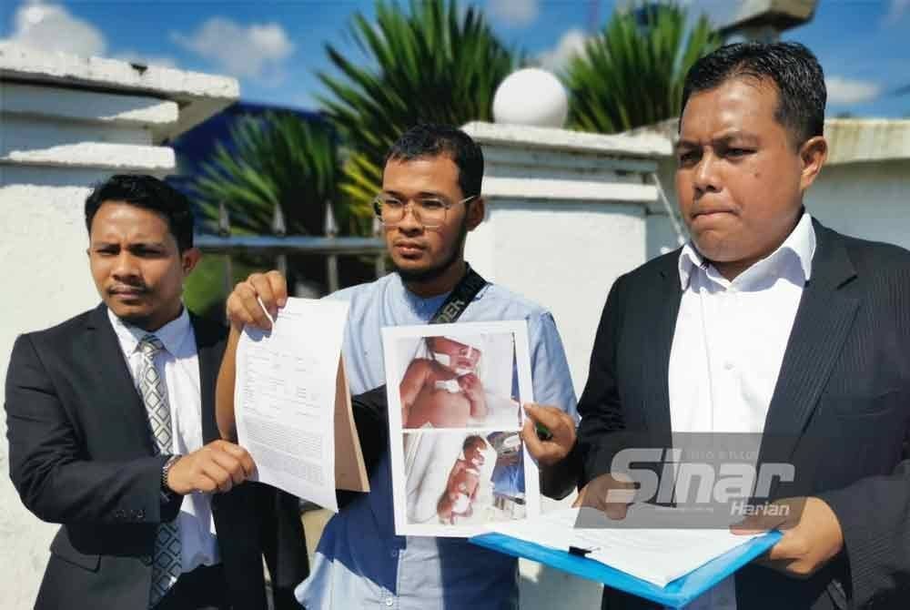 Muhammad Syarifuddin (tengah) membuat laporan polis mendakwa kecuaian kakitangan hospital menyebabkan bayinya terjatuh, cedera pada kepala dan kerap diserang sawan.