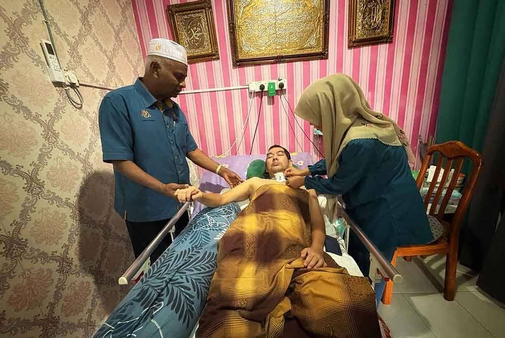 Zainol Abidin (kiri) menziarahi Mohd Faidzal di rumah mereka di Taman Teja di sini pada Khamis.