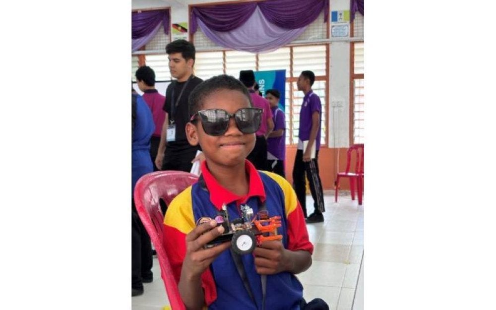  Akil bangga menunjukkan robot yang berjaya diciptanya.