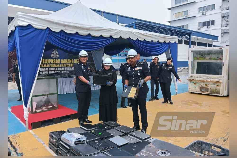 Anbalagan (kanan) bersama Noor Ruzilawati (tengah) melihat barang kes yang akan dilupuskan di IPD Serdang, Selangor pada Jumaat. FOTO SINAR HARIAN - HISYAMUDDIN AYUB.