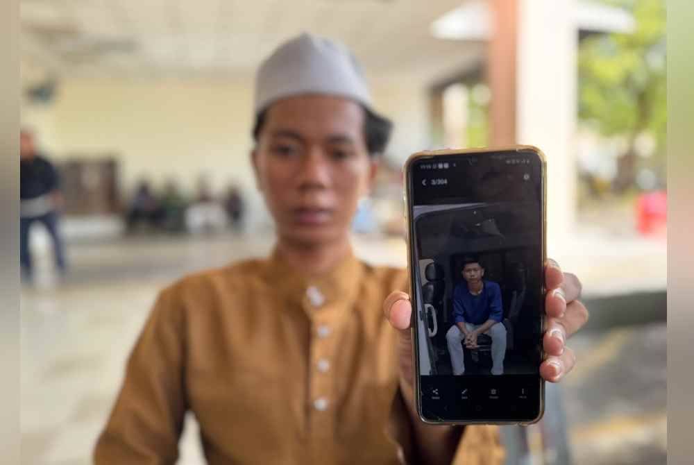 Muhammad Adam menunjukkan gambar arwah adik kembarnya, Muhammad Aidil