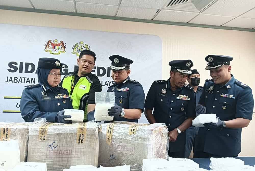 Norlela (kiri) mendengar penerangan daripada pegawai JKDM dan MAHB berhubung rampasan dadah jenis Methamphetamine bernilai RM2.6 juta. Foto: HISYAMUDDIN AYUB
