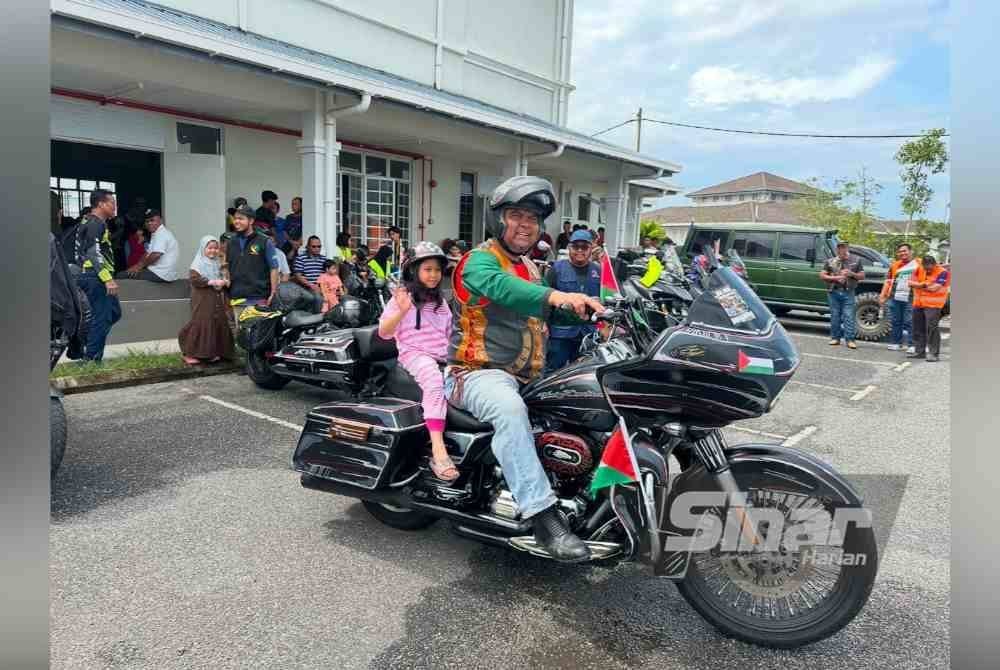 Mangsa banjir kanak-kanak dibawa bersiar-siar naik Harley-Davidson.