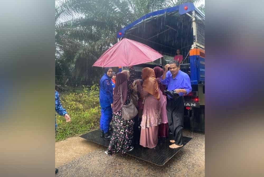 Para guru yang basah kuyup dalam hujan lebat di Kuala Krai.