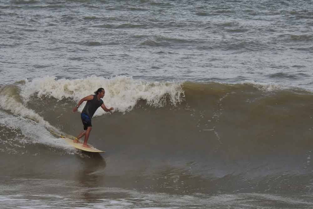 Salah seorang peluncur sedang bermain ombak di Pantai Pelindung di sini. Foto Mr Taufik Idris