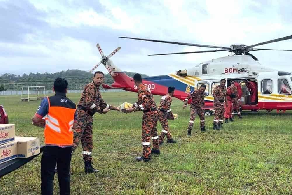Anggota bomba memindahkan barangan untuk dihantar ke lokasi terputus hubungan di Setiu.