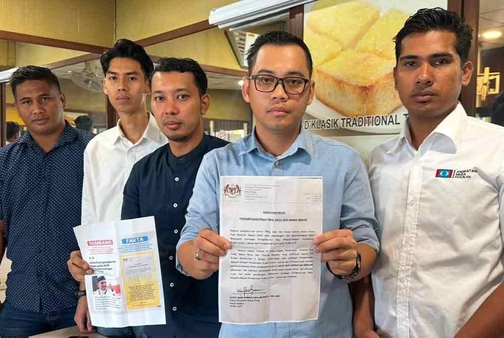 Ezzat (dua dari kanan) yang menunjukkan surat Pengampunan Penuh Anwar pada 2018.