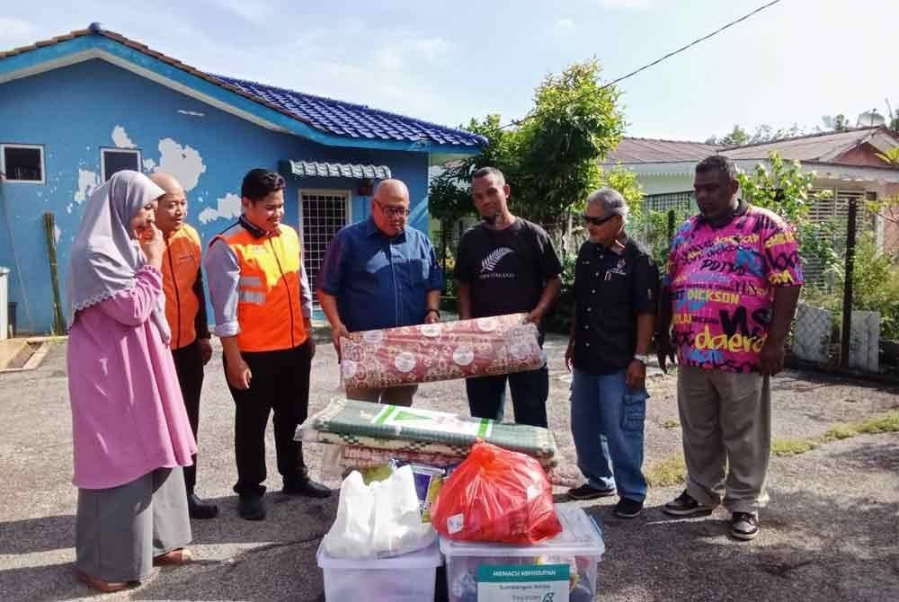 Exco Warisan, Adat- Istiadat Melayu,Teknologi,Inovasi dan Digital negeri, Datuk Mohd Faizal Ramli (empat kiri) menyampaikan sumbangan daripada pihak berkenaan kepada Noor Aiza (tiga kanan).