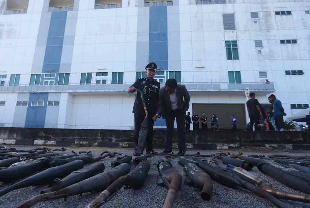 Abdel Nasser (kiri) memeriksa barangan kes aksesori motosikal yang dirampas sebelum dilupuskan di IPK Kedah.