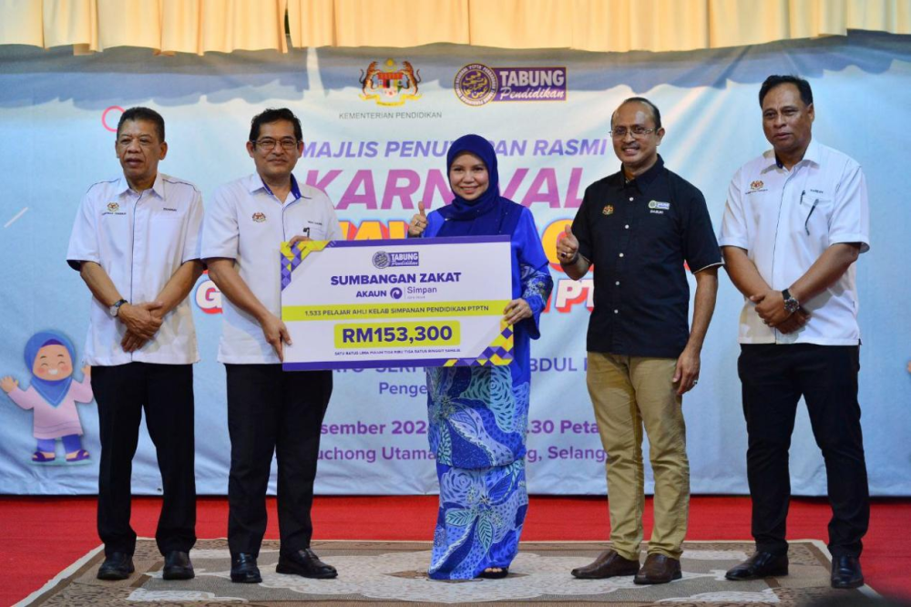 Norliza menyerahkan replika cek sumbangan Tabung Impian Kasih Simpan SSPN berjumlah RM153,300 kepada Wan Hashim yang mewakili KPM.