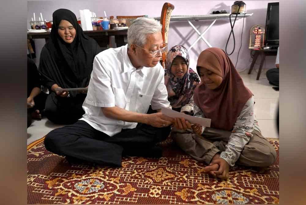 Ismail menyampaikan sumbangan daripada Yayasan Keluarga Malaysia kepada anak yatim.