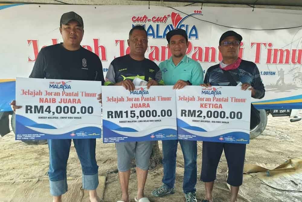 Sharudin (dua dari kanan) menyampaikan hadiah kepada pemenang pertandingan memancing Cuti-Cuti Malaysia Jelajah Joran Pantai Timur.