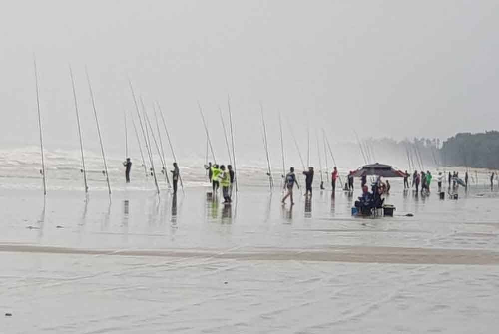 Peserta Cuti-Cuti Malaysia Jelajah Joran Pantai Timur memancing dalam hujan di Pantai Sepat Ahad lalu.