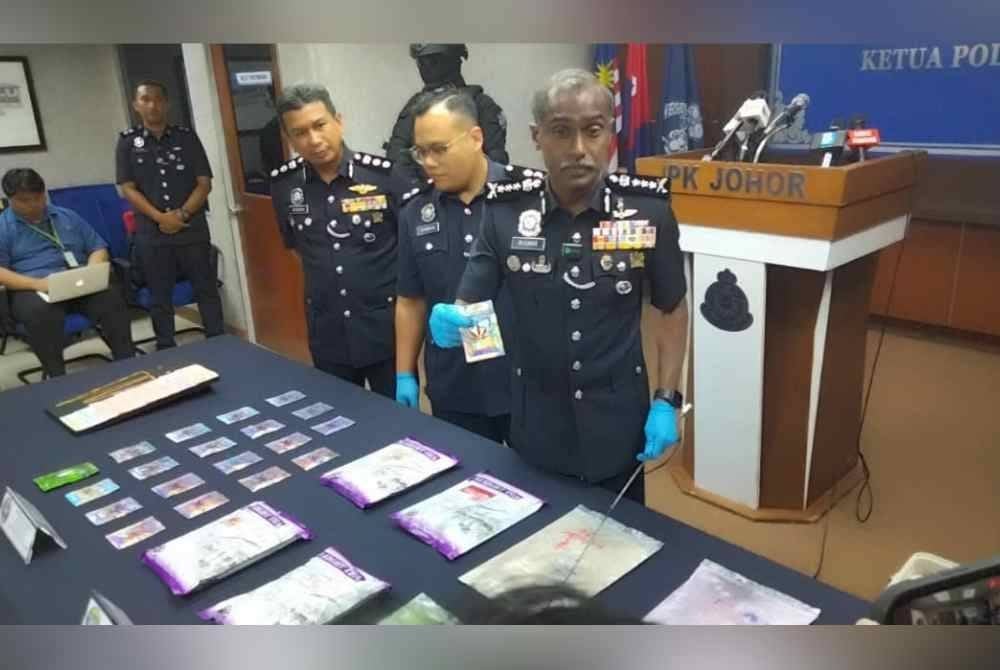 Kumar (kanan) menunjukkan dadah yang dirampas hasil serbuan di Muatiara Rini dan Taman Tun Aminah pada Sabtu.