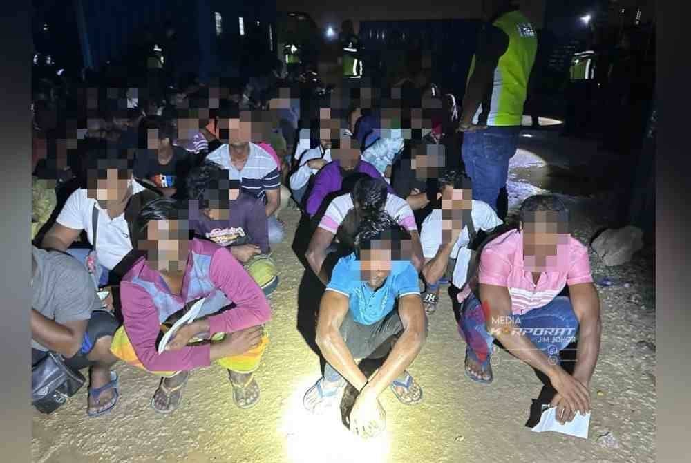 Warga asing yang ditahan dalam Ops Sapu yang dijalankan JIM Johor di penempatan pekerja di tapak pembinaan di Masai, Johor Bahru, awal pagi Rabu. Foto JIM Johor