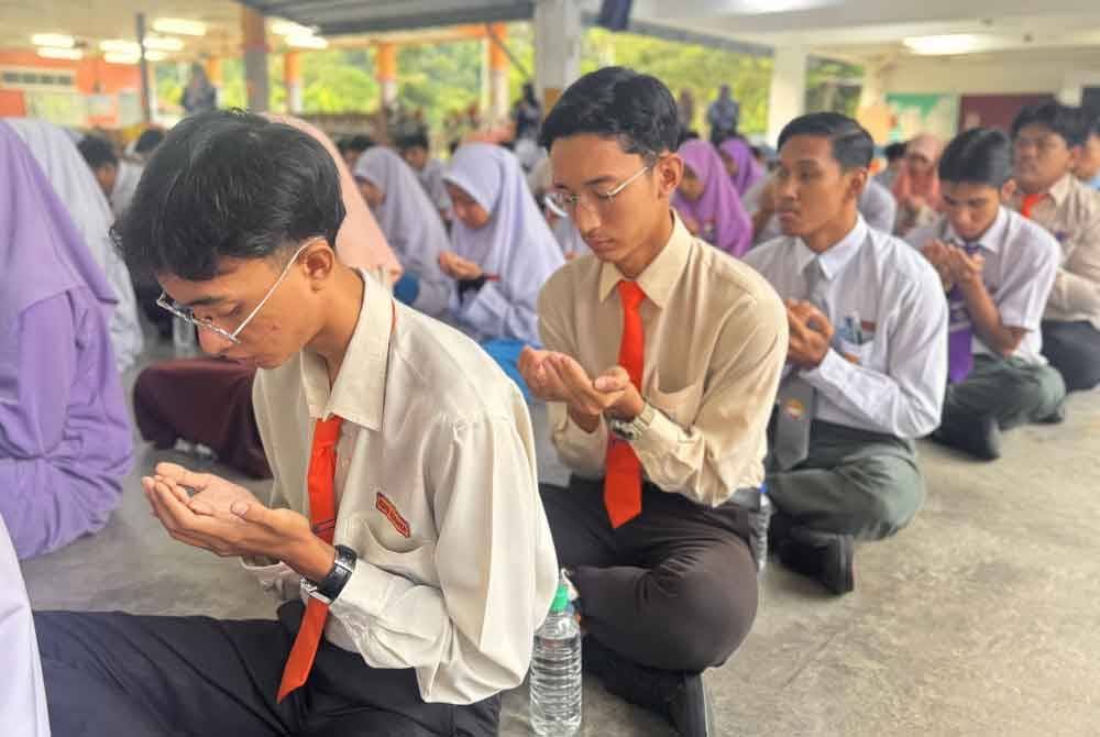 Pelajar SMK Pondok Upeh membaca doa sebelum memasuki dewan peperiksaan.
