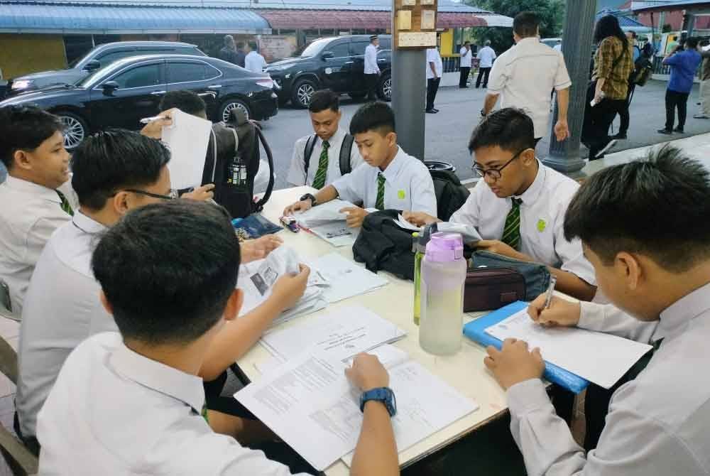 Calon SPM di SMK Tinggi Batu Pahat memanfaatkan masa sebelum memasuki dewan peperiksaan dengan mengulangkaji pepelajaran.