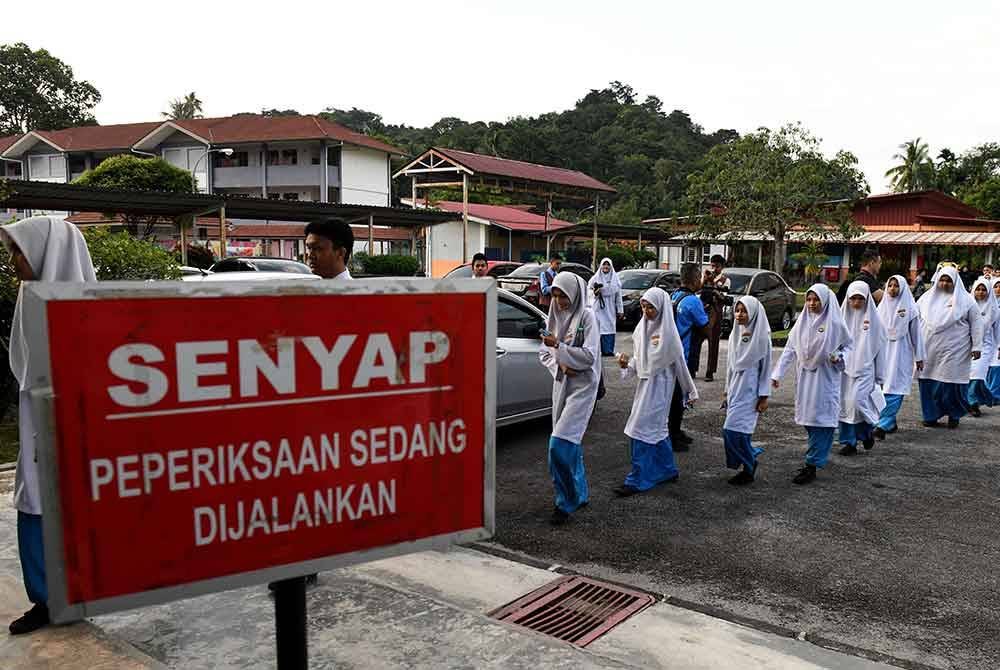 Calon-calon SPM mula masuk ke dewan bagi menduduki peperiksaan bertulis Bahasa Melayu Kertas I di Sekolah Menengah Kebangsaan Pondok Upeh pada Khamis. Foto Bernama