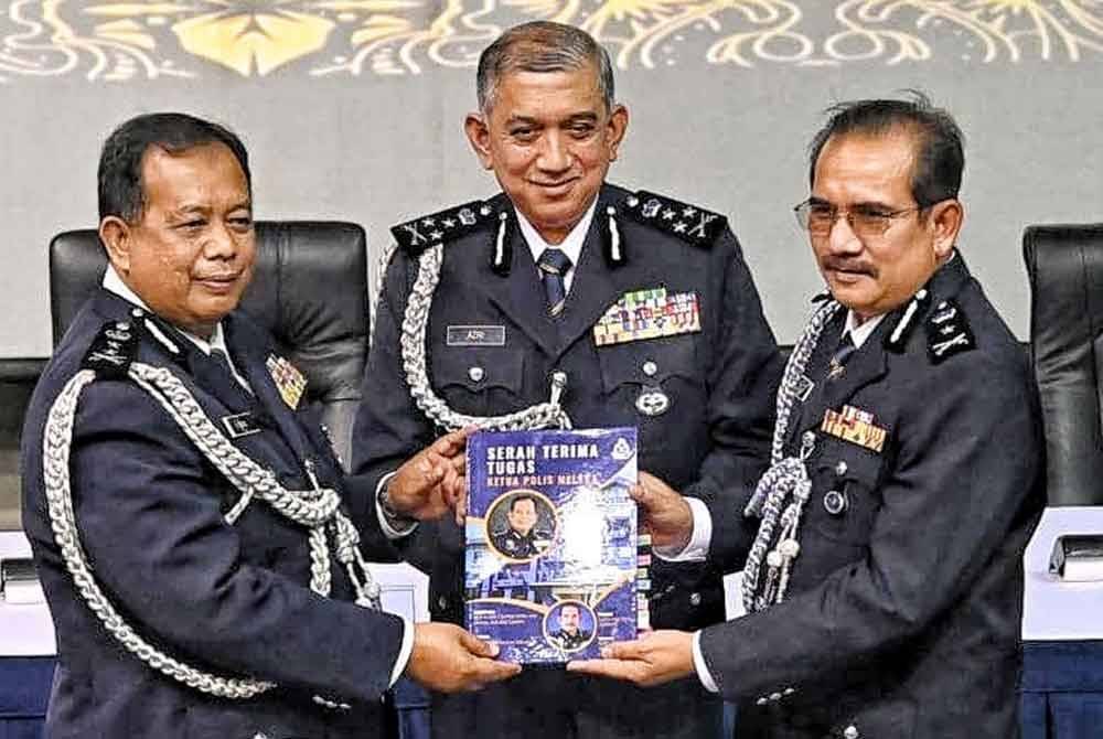 Azri (tengah) menyaksikan upacara penyerahan dokumen serah terima tugas di antara Zainol (kiri) dan Md Nazri (kanan).