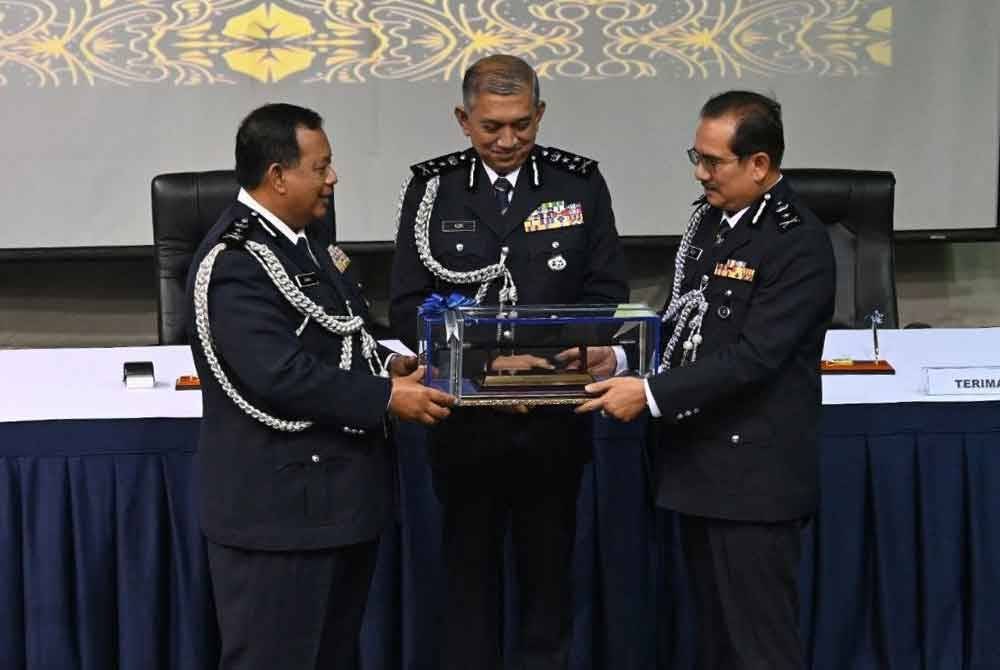 Zainol (kiri) menyerahkan tongkat kuasa kepada Md Nazri (kiri) sambil disaksikan Azri (tengah) pada majlis itu.