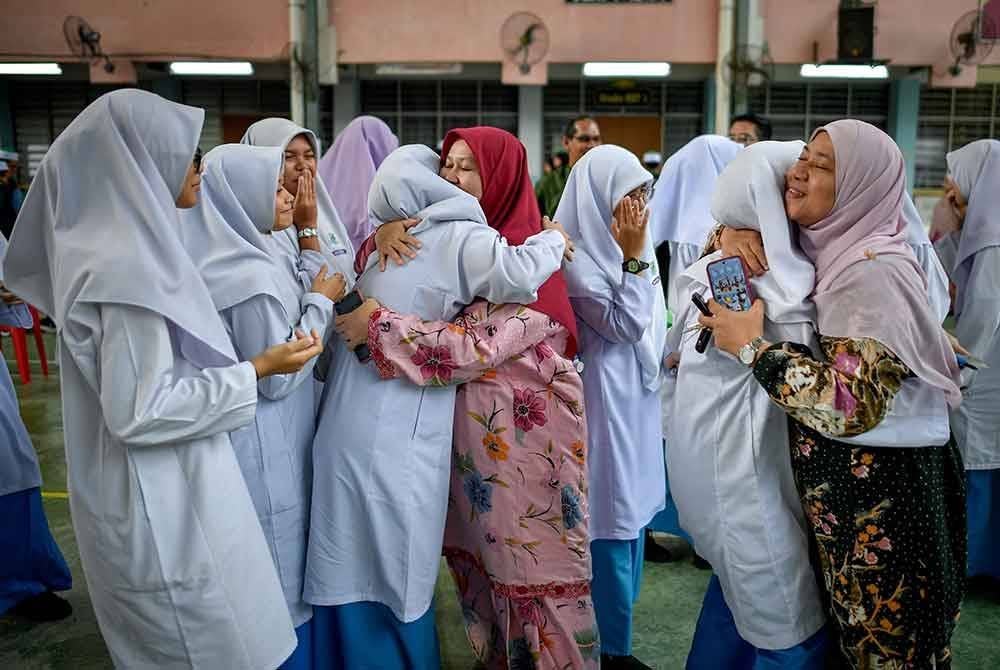 Calon-calon Sijil Pelajaran Malaysia (SPM) memeluk guru sebelum masuk ke dewan peperiksaan pada hari pertama peperiksaan bertulis SPM 2024 di Sekolah Menengah Kebangsaan Jalan Empat dekat Bangi hari ini.